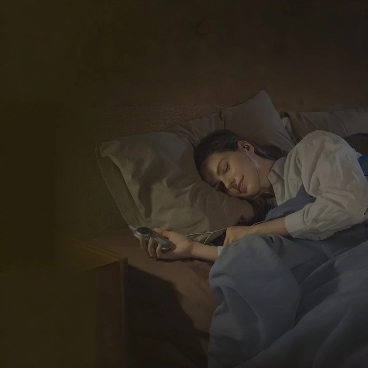 woman using an ear-worn vagus nerve stimulation device while sleeping