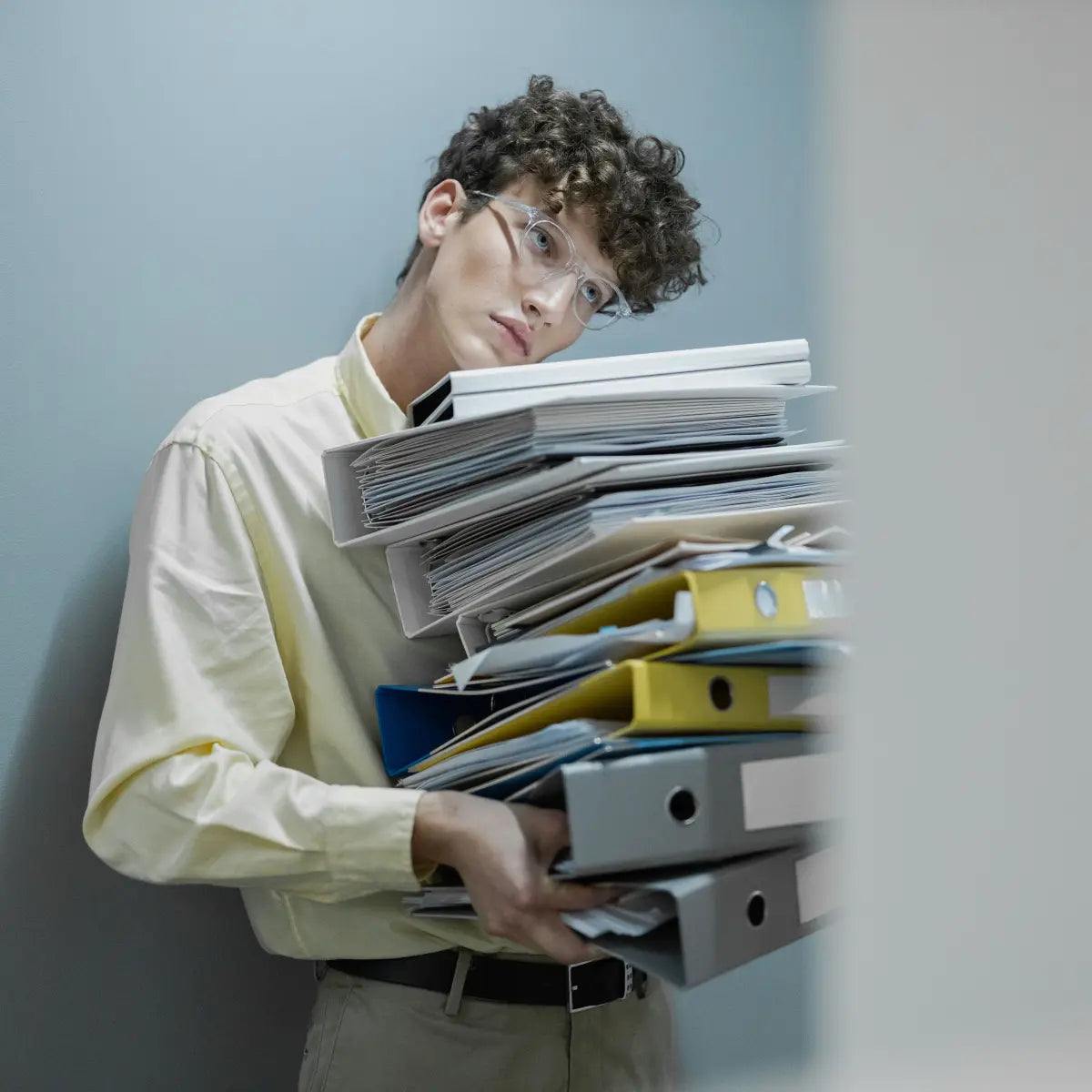 Person carrying a large stack of files, illustrating the accumulating demands of chronic stress