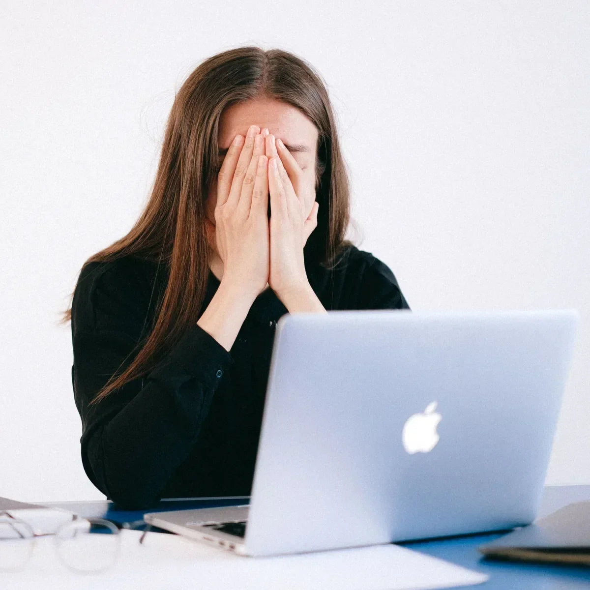 Woman experiencing mental fatigue while working on a laptop, representing brain fog and difficulty concentrating