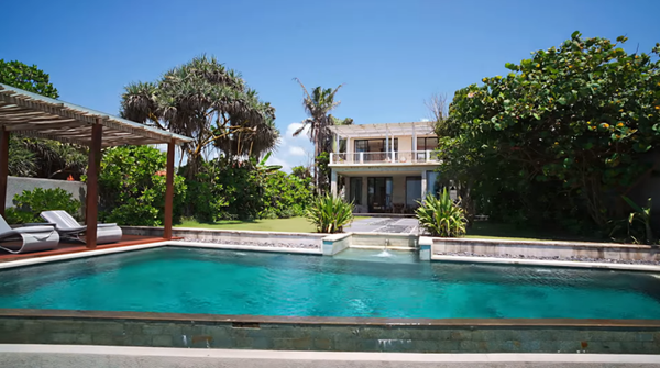 Beachfront wellness retreat villa with a large swimming pool, showcasing a serene setting for Zenowell programs.